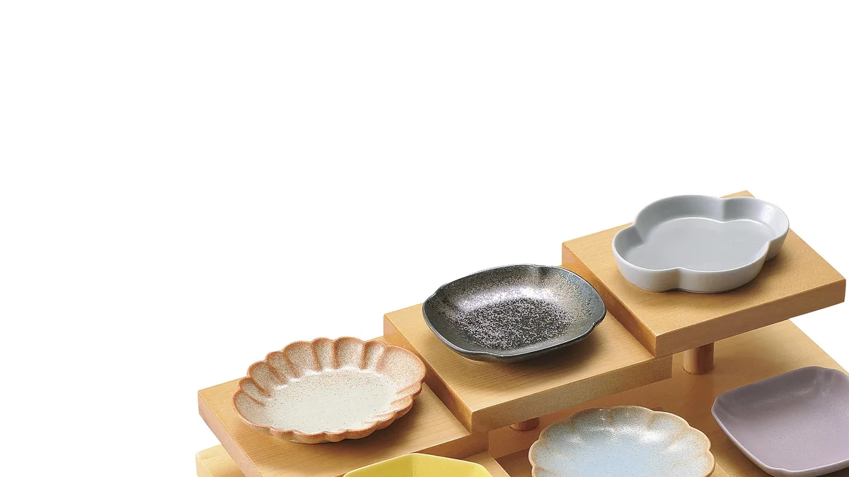 木製の段飾りに菊型や梅型の豆皿・小皿を並べたイメージ。寿司カウンターに合う小皿選びの特集